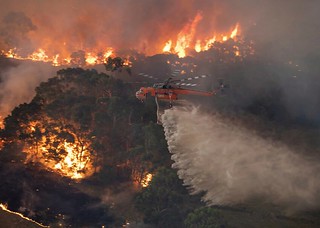 On Monday, Dec. 30, 2019, this photo provided by the State Government of Victoria, shows a helicopter tackles a wildfire in East Gippsland, Victoria state, Australia. (State Government of Victoria via AP)